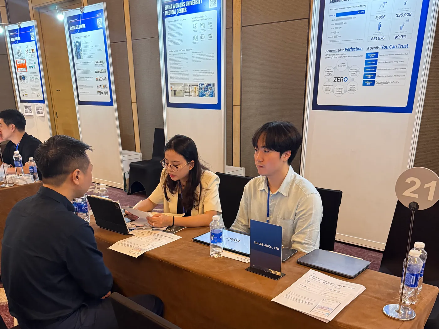 1:1 business meeting with a Vietnamese buyer at the AcuIT and CoLabAd table